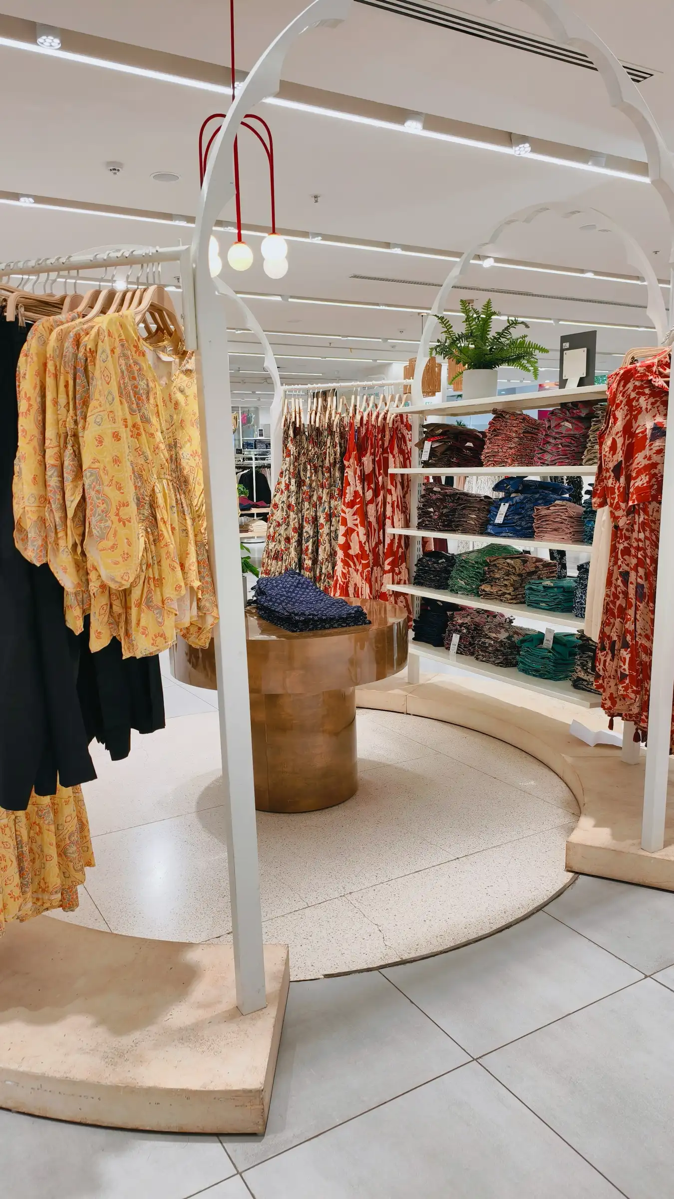 Clothing store sales floor with racks and a bright aisle