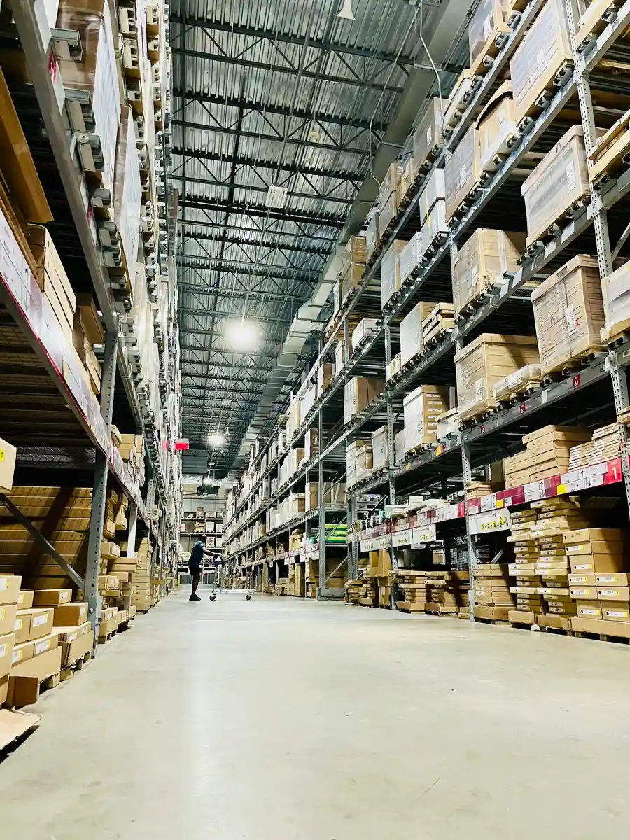Warehouse aisle between tall shelves of cardboard boxes
